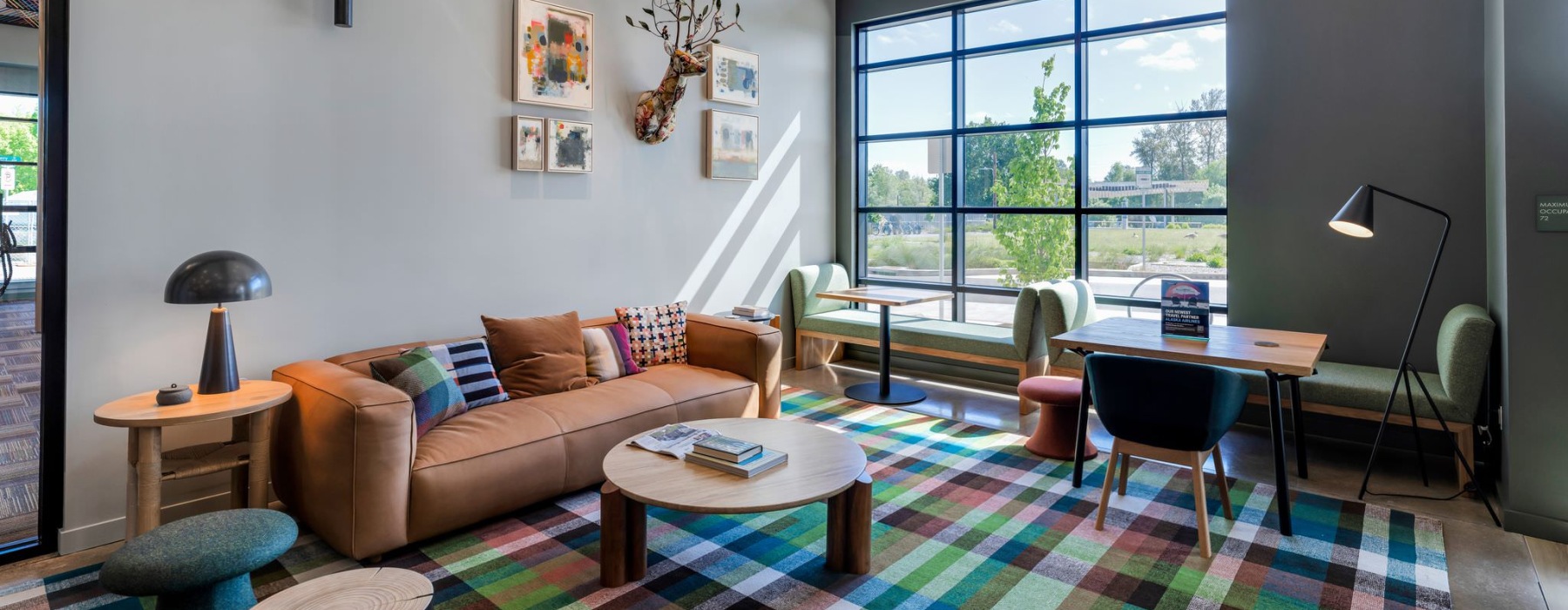 a clubroom with a couch, tables and chairs