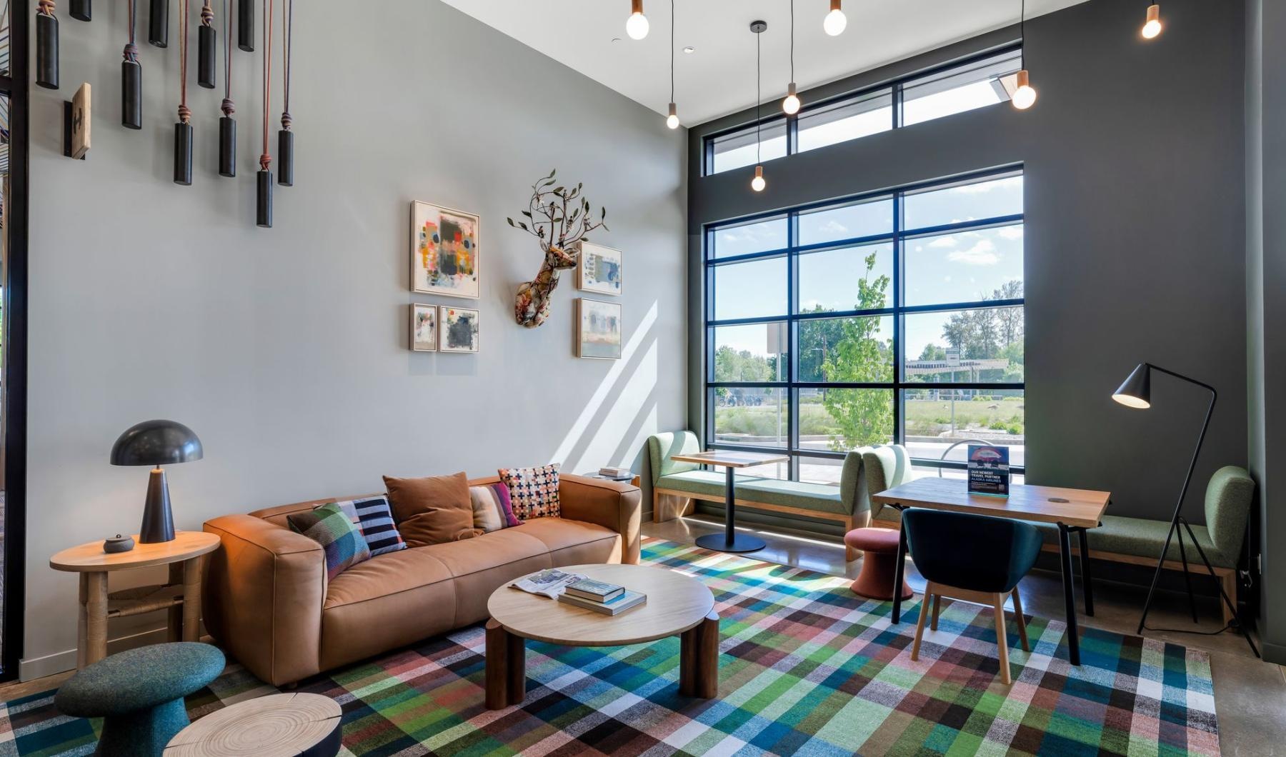 a clubroom with a couch, tables and chairs